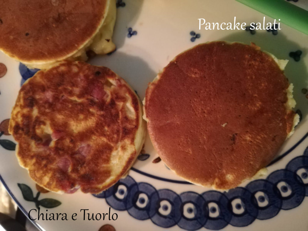 Due pancake salati cotti appoggiati su un piatto, uno girato dalla parte della salsiccia e l'altro dalla parte opposta