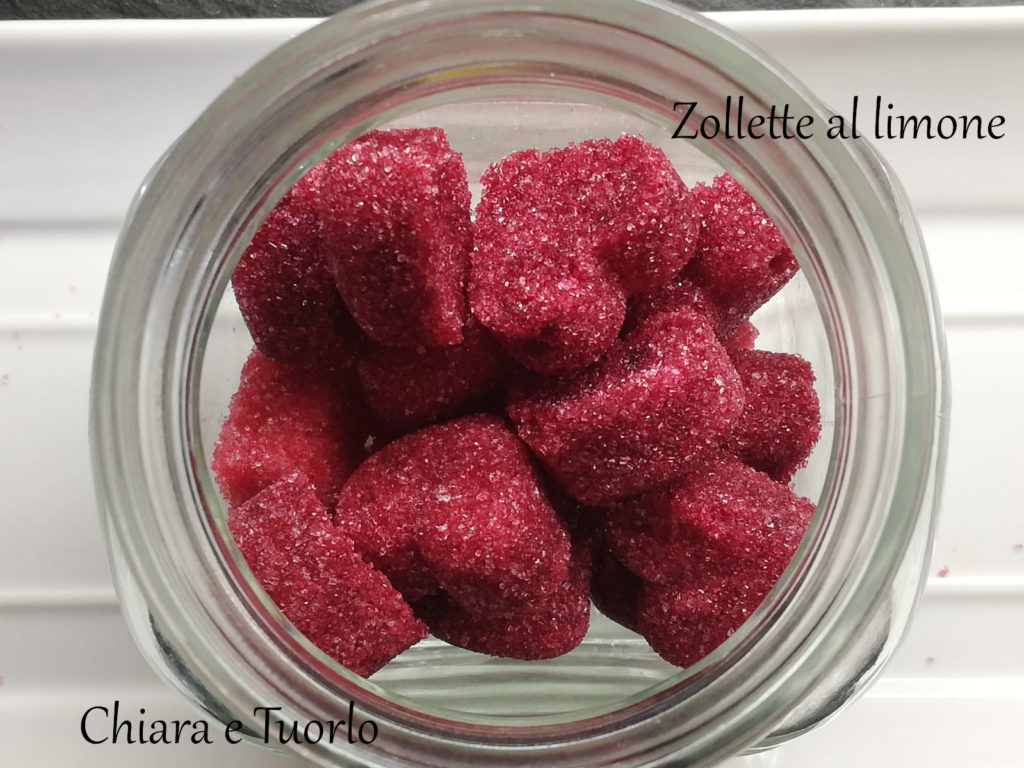 Zollette di zucchero al limone colorate di rosso, a forma di cuore, dentro un vasetto di vetro