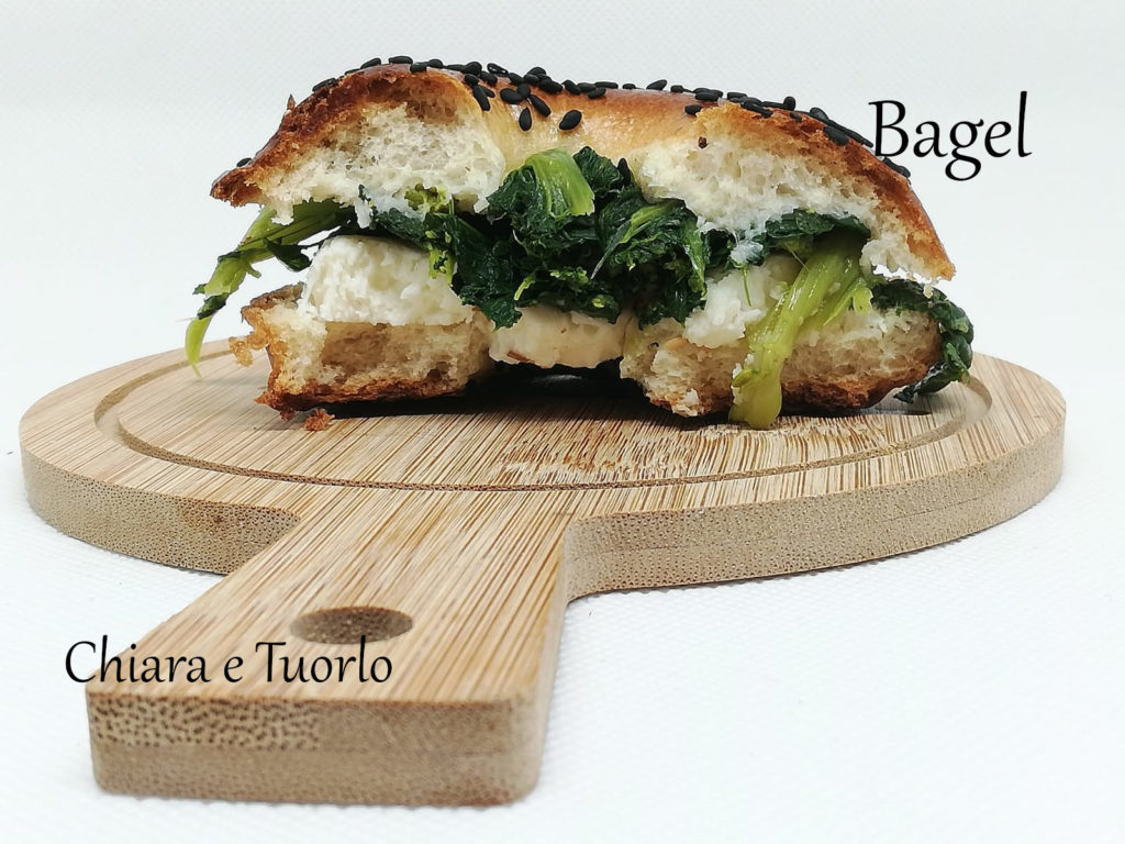 Sezione di Bagel con semi di sesamo nero, farcito con cime di rapa e provola di bufala non affumicata