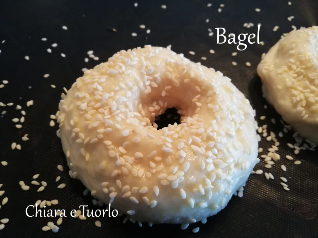 Bagel dopo bollitura, gia' spennellato e cosparso di semi di sesamo