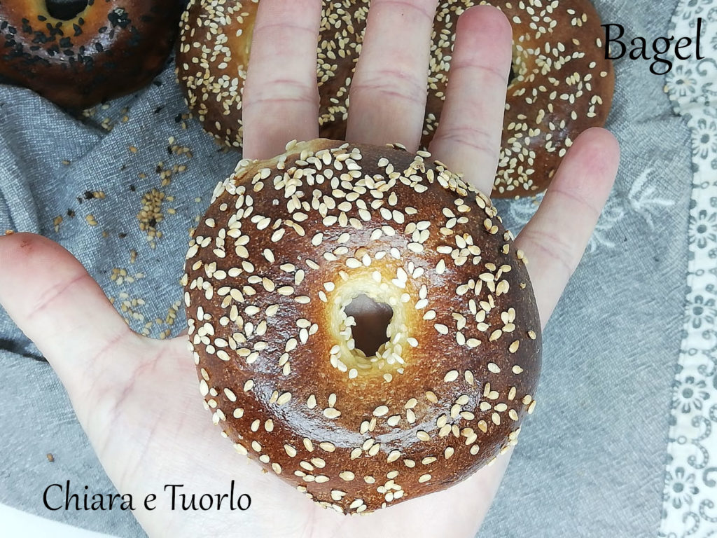 Bagel inquadrato dall'alto posato sul palmo della mano