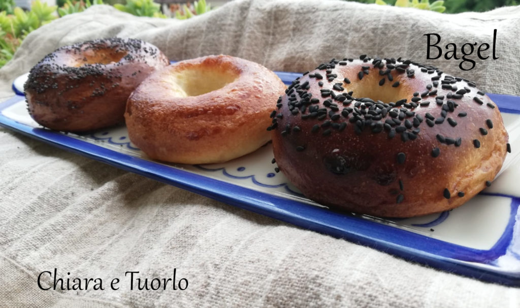 Tre bagel su un vassoio, con sopra semi di papavero, semi di sesamo nero e nulla