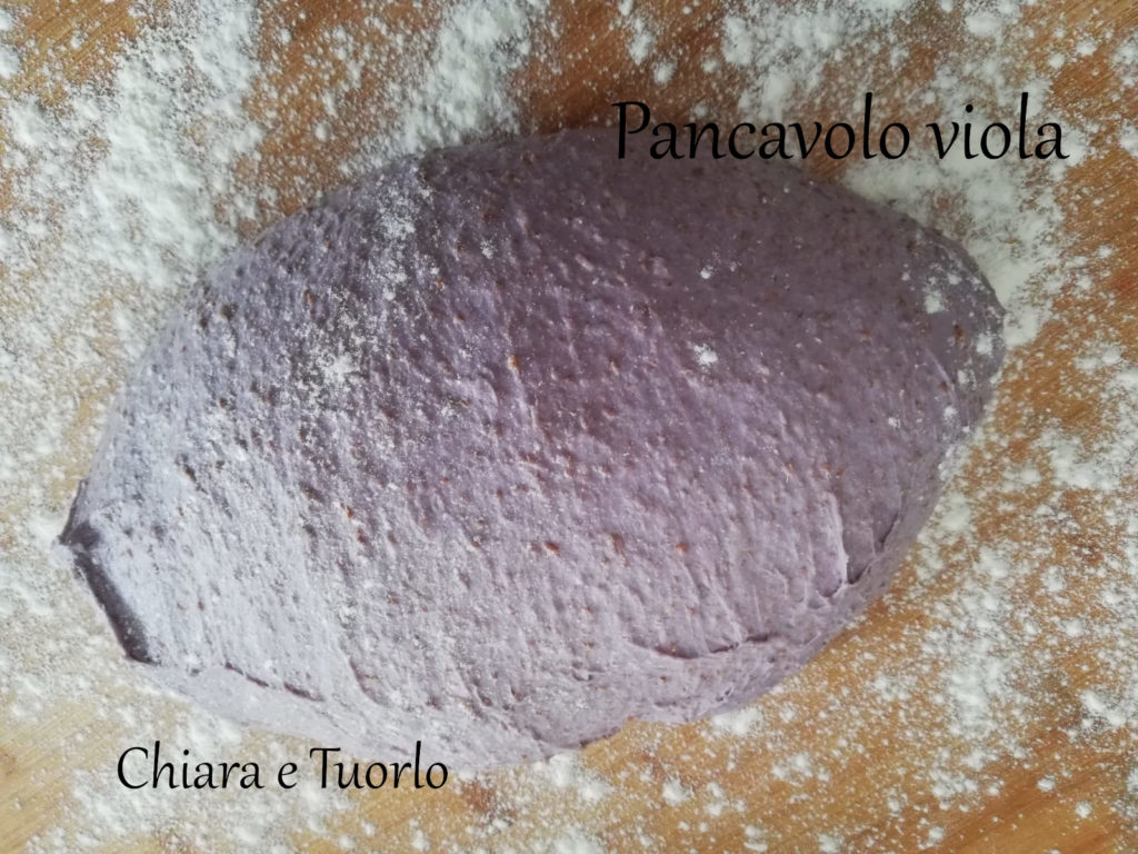 Impasto del Pancavolo viola lievitato, posato sul tagliere di legno con un po' di farina intorno
