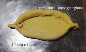 Impasto per il Khachapuri - pane georgiano steso sul piano di lavoro e richiuso con la classica forma