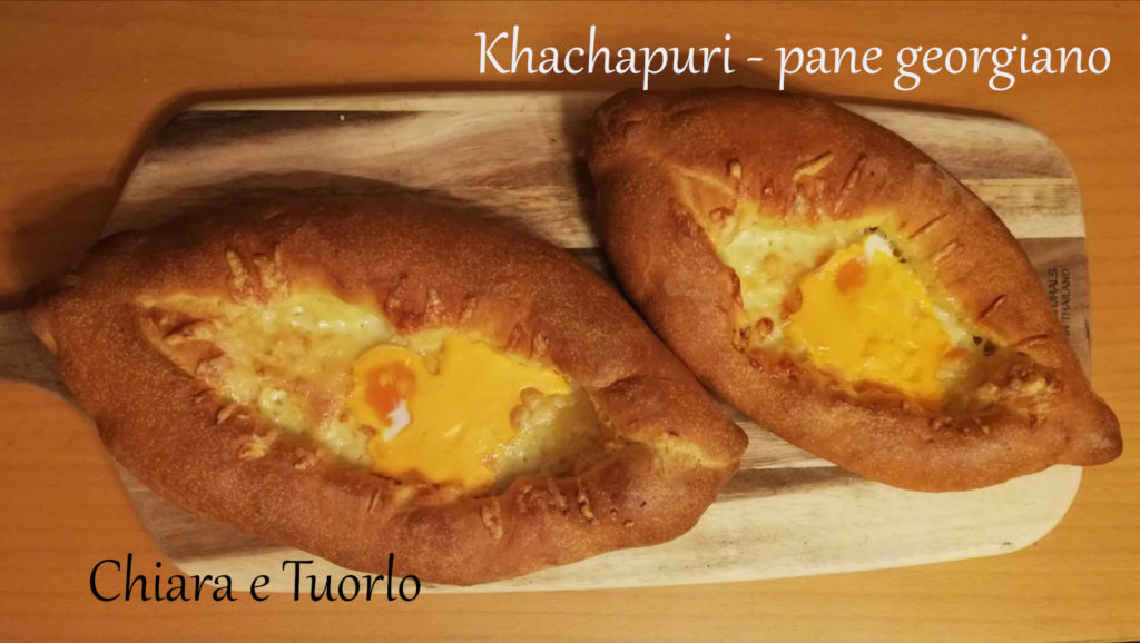 Due Khachapuri - pane georgiano cotti, appoggiati su un tagliere di legno