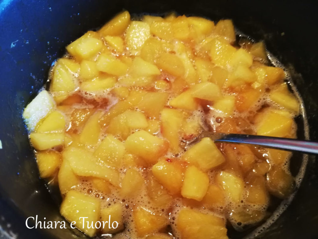 pesche a pezzetti e zucchero nel pentolino, cotte