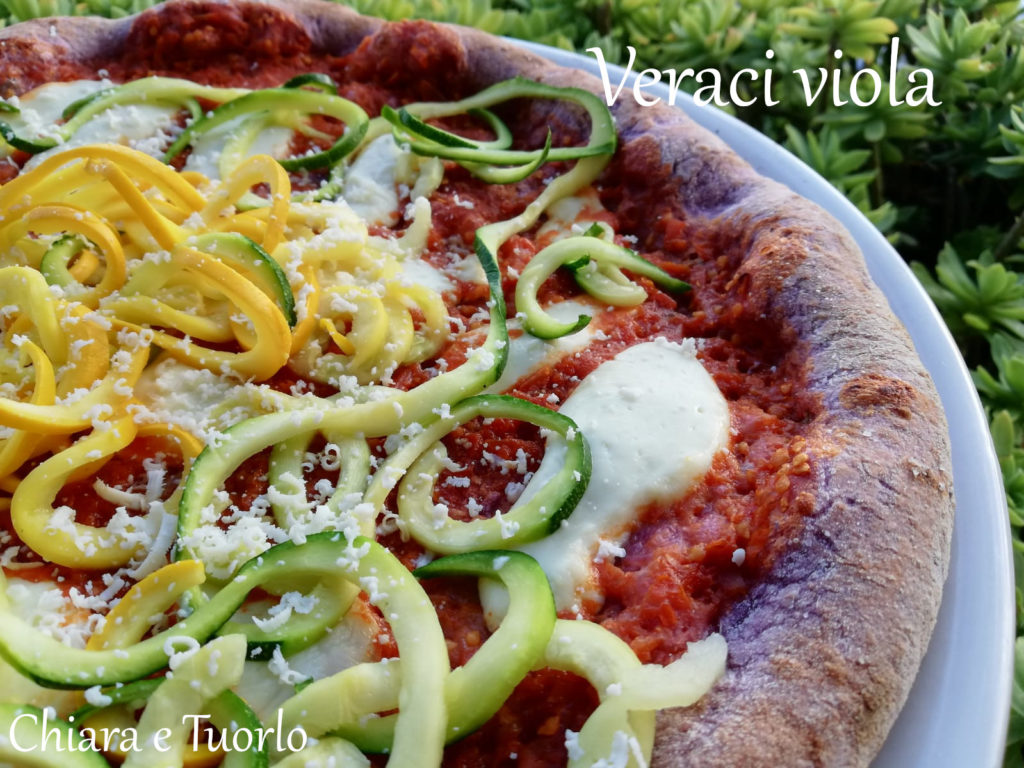 particolare di pizza verace viola cotta e appoggiata su un piatto, farcita con verdure miste
