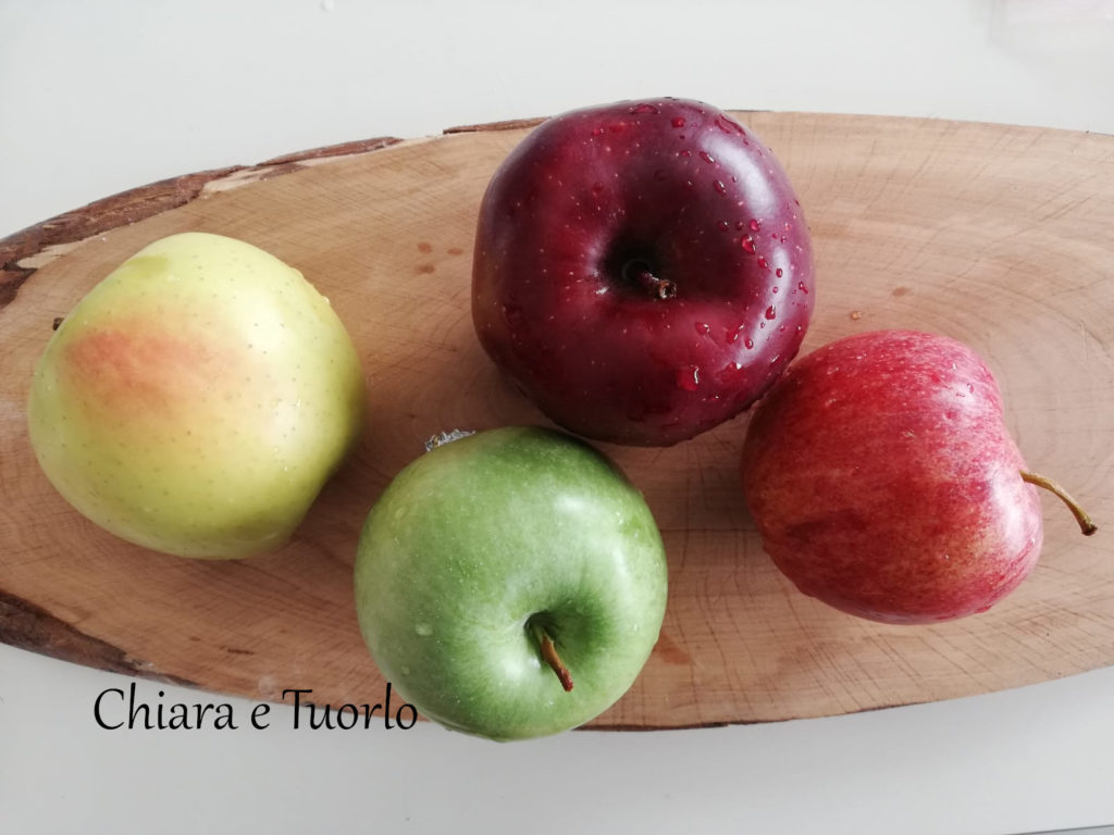 4 diverse mele appoggiate su un tagliere grezzo
