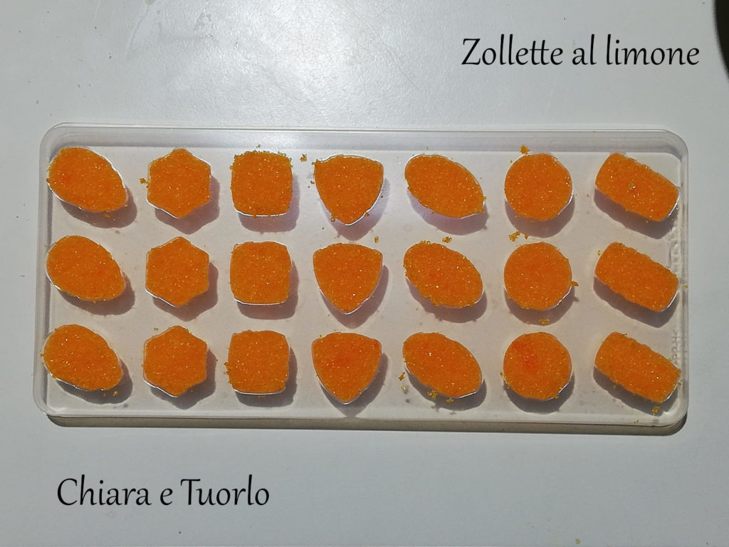 Stampino riempito di zucchero colorato, per preparare le zollette di zucchero al limone di color arancione e con le forme