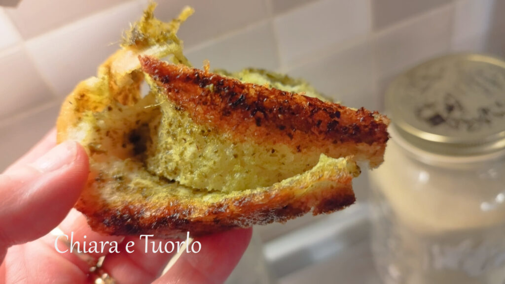 pezzetto di focaccia in mano, quasi sfogliata dal pesto